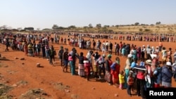 People stand in a queue to receive food aid amid the spread of the coronavirus disease (COVID-19), at the Itireleng informal settlement, near Laudium suburb in Pretoria, South Africa, May 20, 2020. (REUTERS/Siphiwe Sibeko)