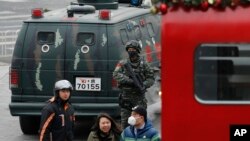 中国武警2015年12月27日在北京三里屯巡逻，可见行人经过警车。