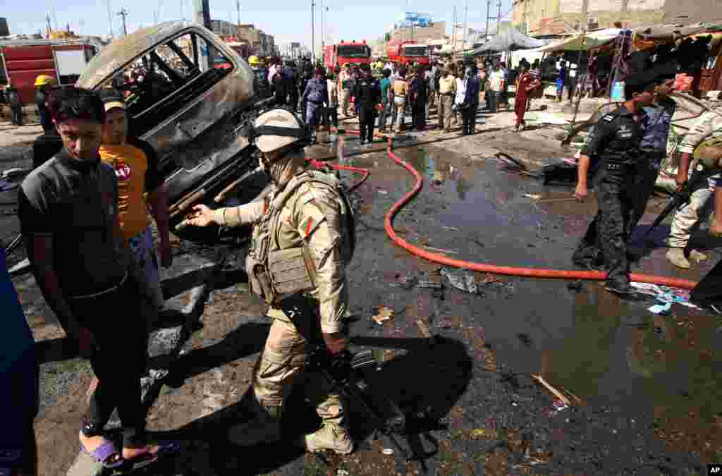 People and security forces inspect the site of a car bomb explosion in Basra, Iraq, July 29, 2013.&nbsp;