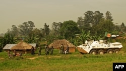 A Bangladeshi patrol from the United Nations Organization Stabilization Mission in the Democratic Republic of the Congo (MONUSCO) passes by Congolese soldiers in Gety, near Kaswara, Ituri province, on Jan. 26, 2016. Renewed fighting in the province has killed dozens of people and created a wave of refugees.