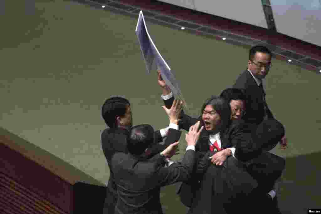 Pro-democracy lawmaker Leung Kwok-hung, also known as &#39;Long Hair,&#39; is blocked by security officials as he tries to approach Hong Kong Chief Executive Leung Chun-ying inside the Legislative Council in Hong Kong. 