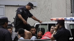 In this Aug. 31, 2012 photo, alleged members of the MS-13 or Mara Salvatrucha gang arrested on murder and gun possession charges are loaded into a police pick-up truck after being presented to the press in San Salvador, El Salvador. 