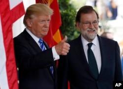 President Donald Trump gives thumbs up as he welcomes Spanish Prime Minister Mariano Rajoy at the White House, Sept. 26, 2017, in Washington.