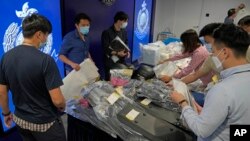 Police officers display seized evidence during a news conference as nine people were arrested over the alleged plot to plant bombs around Hong Kong, at police headquarters in Hong Kong, Tuesday, July 6, 2021. (AP Photo/Kin Cheung)