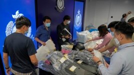 Police officers display seized evidence during a news conference as nine people were arrested over the alleged plot to plant bombs around Hong Kong, at police headquarters in Hong Kong, Tuesday, July 6, 2021. (AP Photo/Kin Cheung)