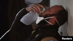 A civil defense member breathes through an oxygen mask, after what rescue workers described as a suspected gas attack in the town of Khan Sheikhoun in rebel-held Idlib, Syria April 4, 2017. 