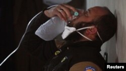 A civil defense member breathes through an oxygen mask, after what rescue workers described as a suspected gas attack in the town of Khan Sheikhoun in rebel-held Idlib, Syria, April 4, 2017. 