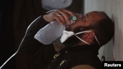 A civil defense member breathes through an oxygen mask, after what rescue workers described as a suspected gas attack in the town of Khan Sheikhoun in rebel-held Idlib, Syria April 4, 2017. 