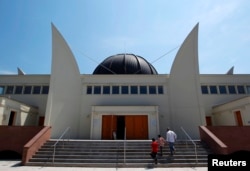 FILE - Members of the Muslim community arrive for midday prayers at Strasbourg Grand Mosque in Strasbourg, France, on the first day of Ramadan, July 9, 2013.