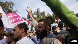 A man holds a copy of the Quran during pro-Morsi rally outside Cairo University, Dec. 1, 2012.