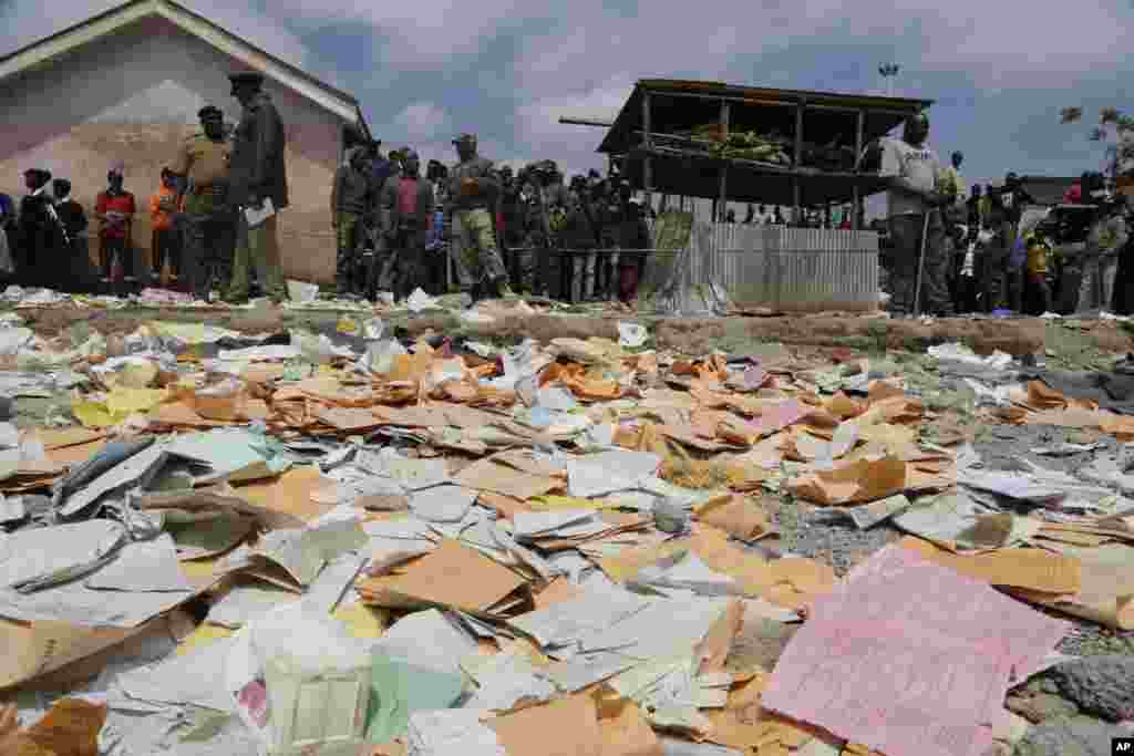 School papers lie on the ground as people gather at the site of the Precious Talent Top School building after it collapsed in Nairobi, Kenya, killing at least seven children.