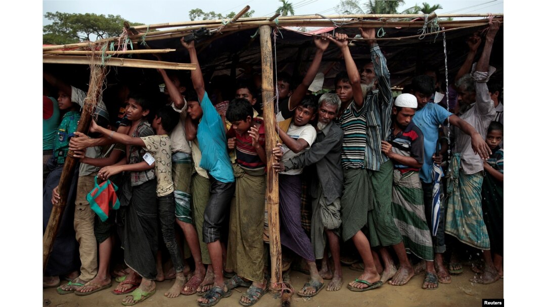 Rohingya refugees jostle as they line up for a blanket distribution under heavy rainfall at the Balukhali camp near Cox's Bazar, Bangladesh, Dec. 11, 2017.