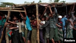 Rohingya refugees jostle as they line up for a blanket distribution under heavy rainfall at the Balukhali camp near Cox's Bazar, Bangladesh, Dec. 11, 2017.