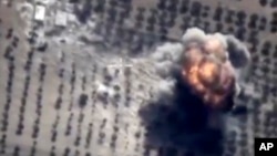 This photo made from the footage taken from Russian Defense Ministry official web site on Oct. 16, 2015 shows a target hit during a Russian air raid in Syria. Russian Defense Ministry said the strike was performed by an Su-24M bomber in Idlib.