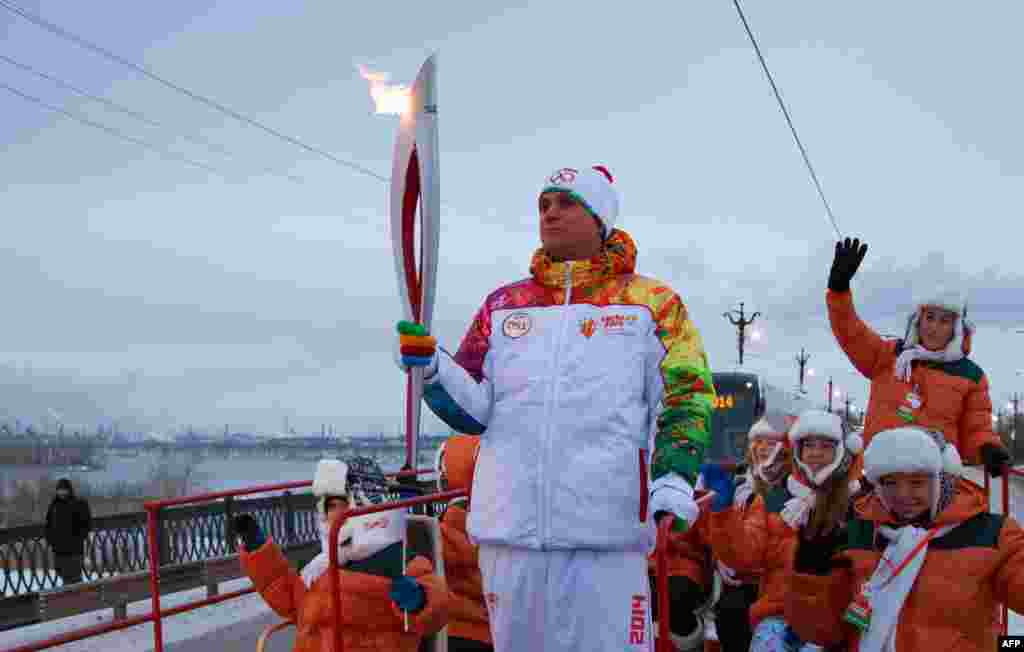 A handout picture taken during the Sochi 2014 Winter Olympic torch relay shows Russian torchbearers carrying the torch ahead of ahead of the Sochi Winter Games, Moscow, Russia, Dec. 18, 2013. 