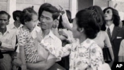 Neou Sarem says goodbye to her husband, Nuon Sari, and her 3-year old daugther, Nuon Sari Sakhura, at Pochentong Airport, 1974.