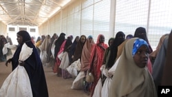 Somali refugees wait in line to receive food rations at a World Food Program distribution point in Ifo Camp, outside Dadaab, Kenya, July 15, 2011