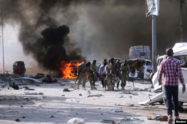 Somalian government forces evacuate their injured colleague, from the scene of an explosion in KM4 street in the Hodan district of Mogadishu, Oct. 14, 2017.