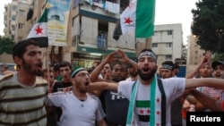 Lebanese and Syrian citizens celebrate reports of the deaths of members of Syrian President Bashar al-Assad's inner cirle at a rally in Tripoli, northern Lebanon, July 18, 2012.