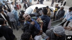 Protestors carry an injured man from the site of clashes with security forces in Sana'a, Yemen, December 24, 2011.