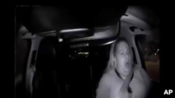 Image made from video, March 18, 2018, of a mounted camera provided by the Tempe Police Department, shows a human backup driver in Uber SUV looking down seconds before it hit a woman in Tempe, Ariz.
