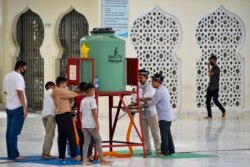 Sejumlah pria mencuci tangan sebelum salat Jumat di tengah kekhawatiran penyebaran virus corona (Covid-19), di masjid Baiturrahman, di Banda Aceh, 29 Mei 2020. (Foto: AFP)