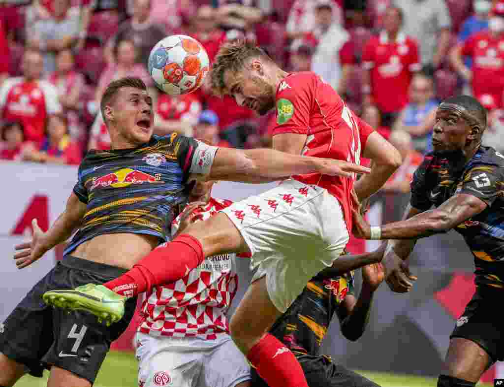 Mainz&#39;s Alexander Hack, center, and Leipzig&#39;s Willi Orban, left, fight for the ball during the German Bundesliga soccer match between FSV Mainz 05 and RB Leipzig in Mainz, Germany.