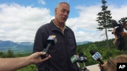 FILE - Interior Secretary Ryan Zinke talks with reporters with part of Mount Katahdin in the background at the Katahdin Woods and Waters National Monument near Staceyville, Maine, June 14, 2017.