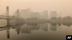 A view of downtown Portland from the East Bank Esplanade is seen on Monday, Sept. 14, 2020. The entire Portland metropolitan region remains under a thick blanket of smog from wildfires. (AP Photo/Gillian Flaccus)