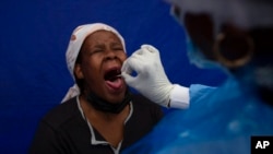 A patient gets a throat swab to test for COVID-19 at a facility in Soweto, South Africa, Dec. 2, 2021. 