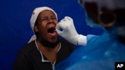 A patient gets a throat swab to test for COVID-19 at a facility in Soweto, South Africa, Dec. 2, 2021. 