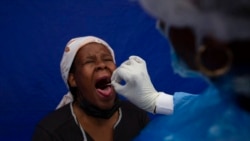 A patient gets a throat swab to test for COVID-19 at a facility in Soweto, South Africa, Dec. 2, 2021.