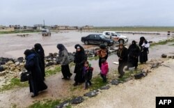 Syrian civilians cross from rebel-held areas in Idlib province into regime-held territories on December 27, 2018, through the Abu Duhur crossing.
