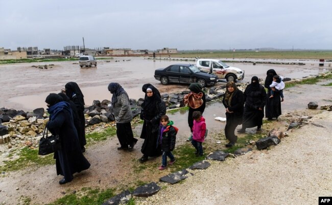 Syrian civilians cross from rebel-held areas in Idlib province into regime-held territories on December 27, 2018, through the Abu Duhur crossing.