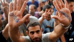 A migrant shows his painted hands in front of the railway station in Budapest, Hungary. The travelers have been trying to go west to Germany or Austria to seek asylum.