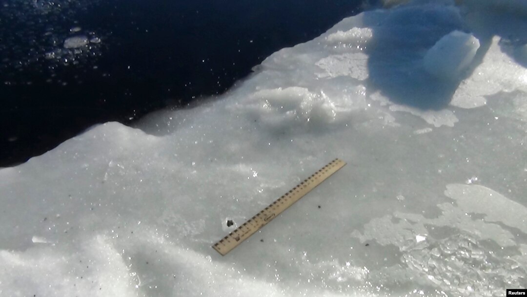 Científicos utilizan una regla para medir los fragmentos del meteorito encontrados alrededor del lago.