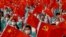 表演者在 2021年7月1日在中国北京天安门广场庆祝中国共产党成立100周年的活动彩排时挥舞着国旗和党旗。