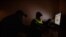 Homeless high school student Frank Hardy looks over homework with his mother at the PATH shelter where they live in Los Angeles, Dec. 9, 2021. 