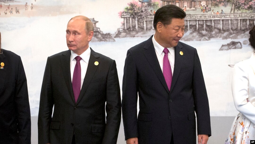 Russian President Vladimir Putin, left, and Chinese President Xi Jinping line up for a photo during the BRICS Summit in southeastern China's Fujian province, Sept. 4, 2017.