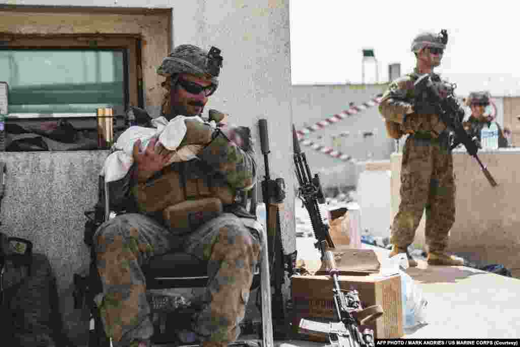 امریکی فوج کے اہلکار کم سن بچے کو گود میں لیے ہوئے ہیں۔