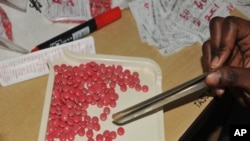 FILE - A health worker counts antiretroviral drug tablets for a patient at The AIDS Support Organization (TASO) in the capital Kampala, Uganda, July 12, 2012. 