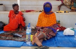 FILE - Displaced women sit on mats after fleeing an attack claimed by Islamic State-linked insurgents on the town of Palma, at a displacement center in Pemba, Mozambique, April 2, 2021.