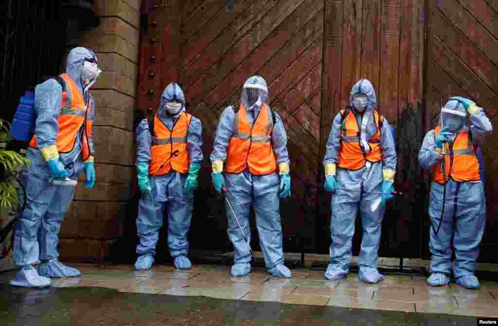 Municipal workers wearing personal protective equipment wait to enter Bollywood actor Amitabh Bachchan&#39;s residence for sanitization after he and his son, actor Abhishek Bachchan, tested positive for the coronavirus disease (CIVID-19), in Mumbai, India.