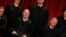 FILE - U.S. Supreme Court Justice Anthony Kennedy (L) reacts while chatting with Chief Justice John Roberts (R) during a new U.S. Supreme Court family photo.