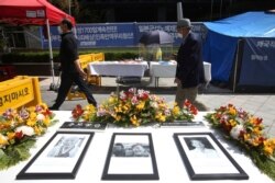 FILE - Portraits of the late former South Korean comfort women are displayed near Japanese Embassy in Seoul, South Korea, Apr. 21, 2021.