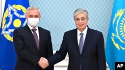 Kazakhstan's President Kassym-Jomart Tokayev, right, shakes hands with the secretary-general of the Collective Security Treaty Organization, Stanislav Zas, prior to their talks in Nur-Sultan, Kazakhstan, Jan. 12, 2022. (Kazakhstan's Presidential Press Service via AP)