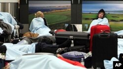 Passengers rest on the floor as their flights have been canceled at Edinburgh Airport in Edinburgh, Scotland, May 24, 2011