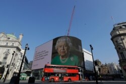 An image of Britain's Queen Elizabeth II and quotes from her historic television broadcast commenting on the coronavirus pandemic are displayed on a big screen at Piccadilly Circus in a locked-down London, April 9, 2020.