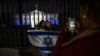 白宮2023年10月9日晚亮出以色列國旗的燈光，支持者們在大門前留影。（法新社）