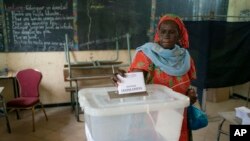 FILE - A woman casts her vote for legislative elections, at a polling station in Dakar, Senegal, July 31, 2022.